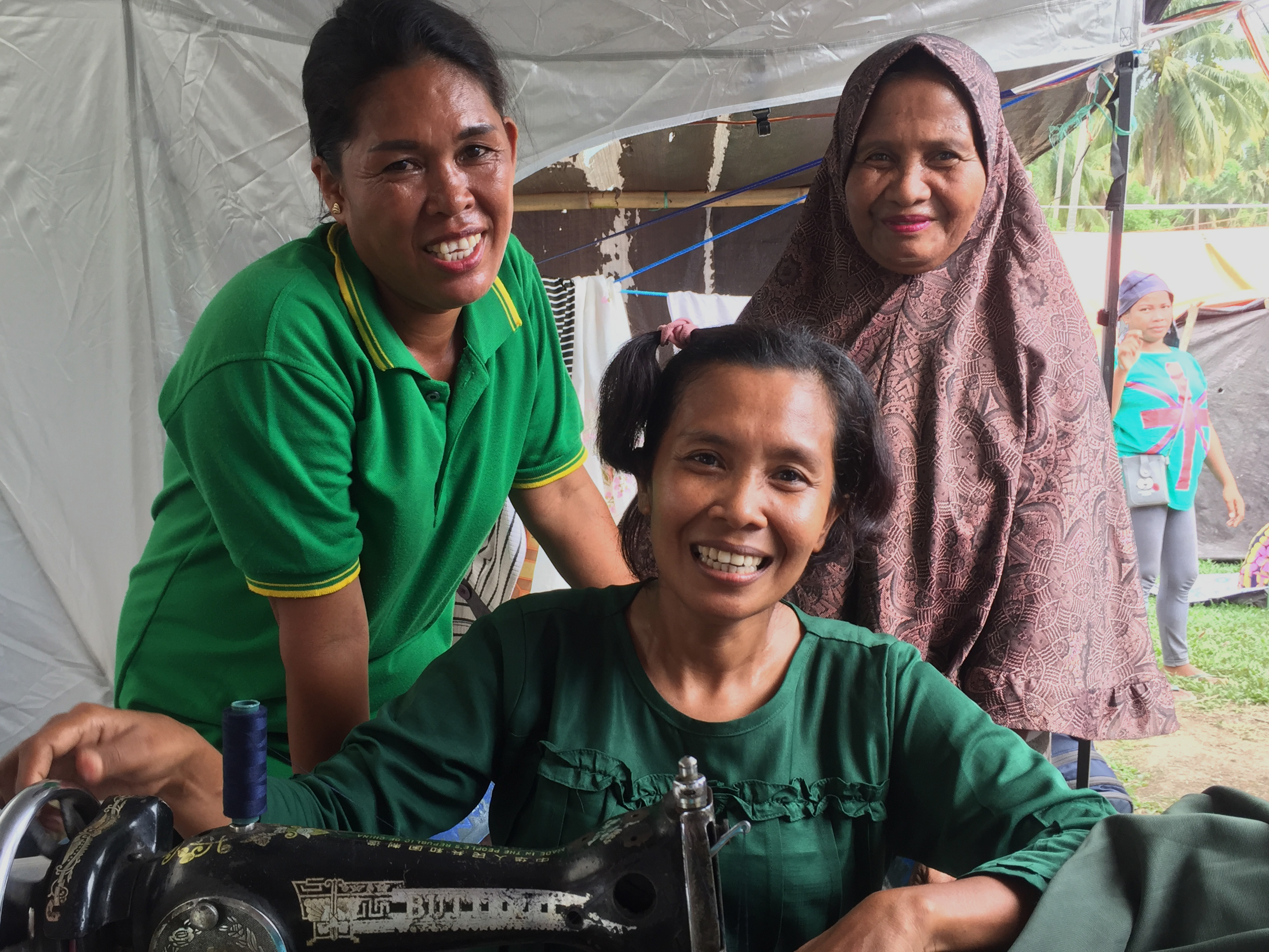A recipient of ShelterBox aid sews within her tent in Indonesia