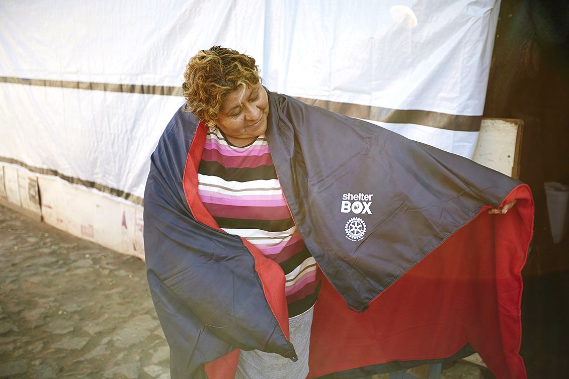 A recipient of ShelterBox aid with her thermal blanket after flooding in Paraguay